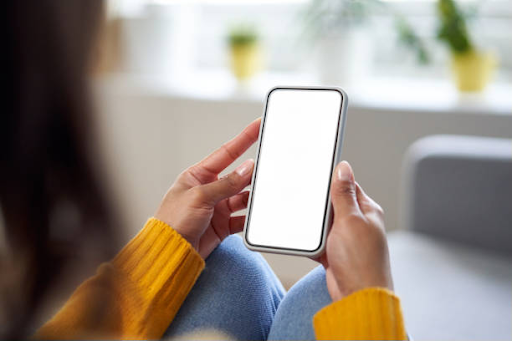 Person holding a smartphone with a blank screen, illustrating the mobile app development market.